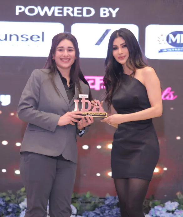 Dr. Prerna receiving an award from Mouni Roy